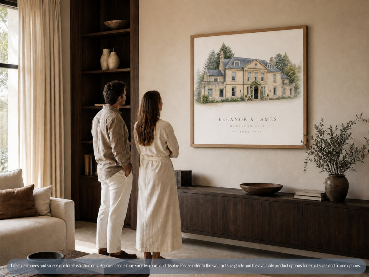 A couple stands beneath a large personalised wedding venue portrait displayed above a living-room cabinet.