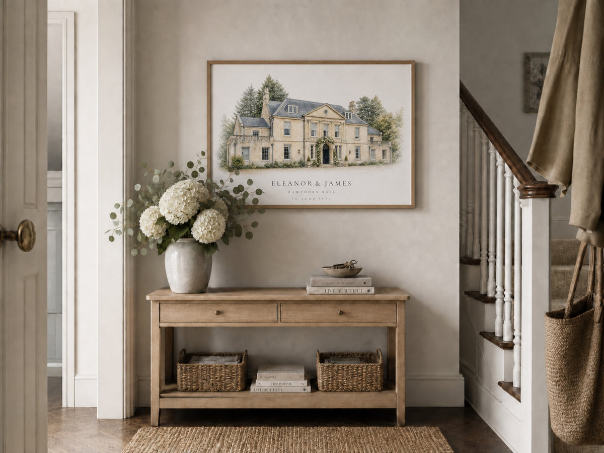 Personalised venue portrait displayed above a console table in a softly styled hallway.